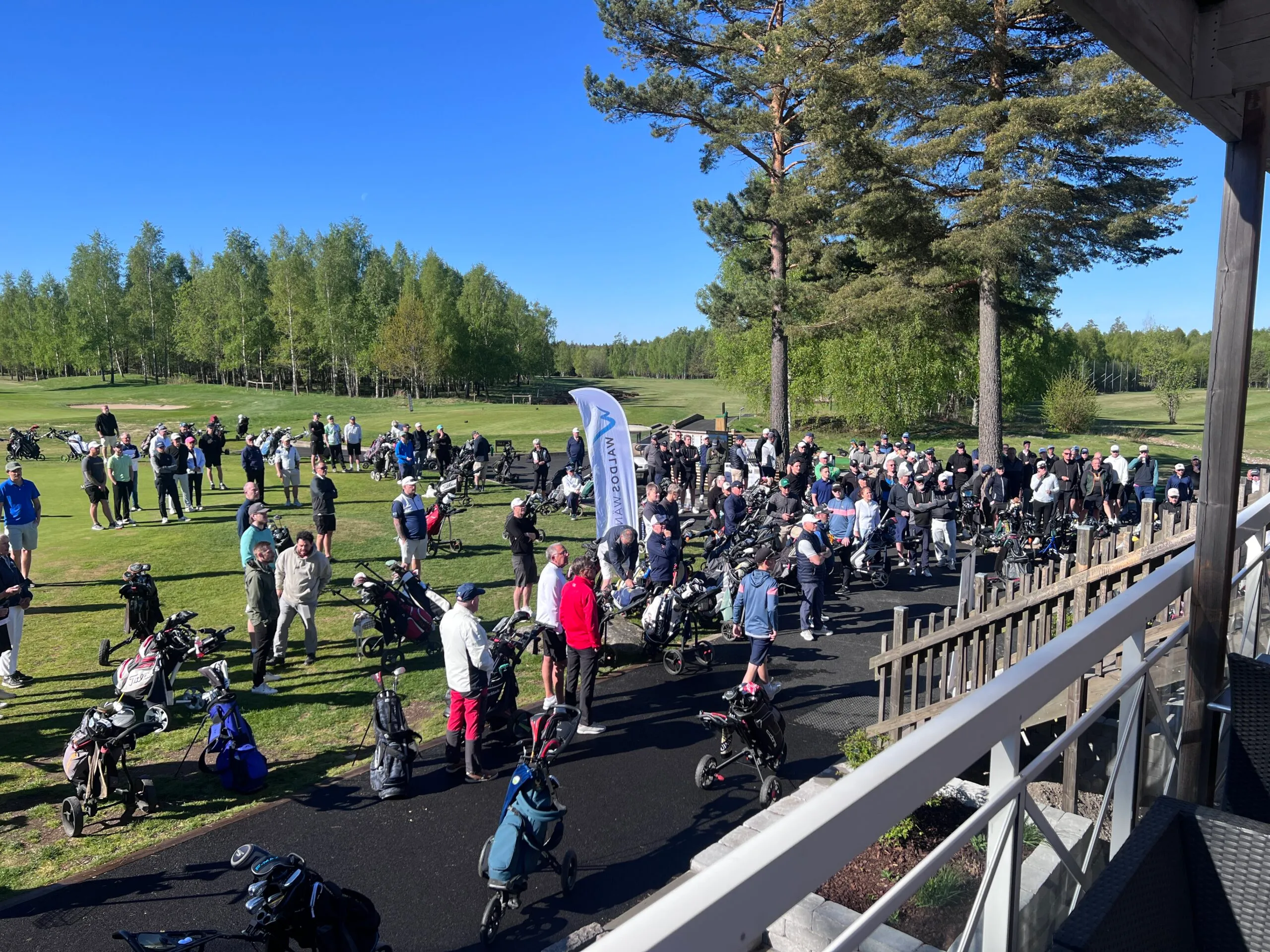 Golfare samlas vid Waldos Wänners flagga inför starten av WW Golf 2026